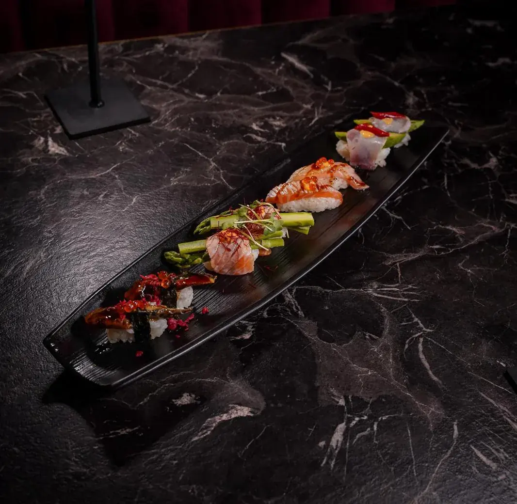 Nigiri mit verschiedenen Fischauflagen, bei Tokoro auf einer langen Platte angerichtet